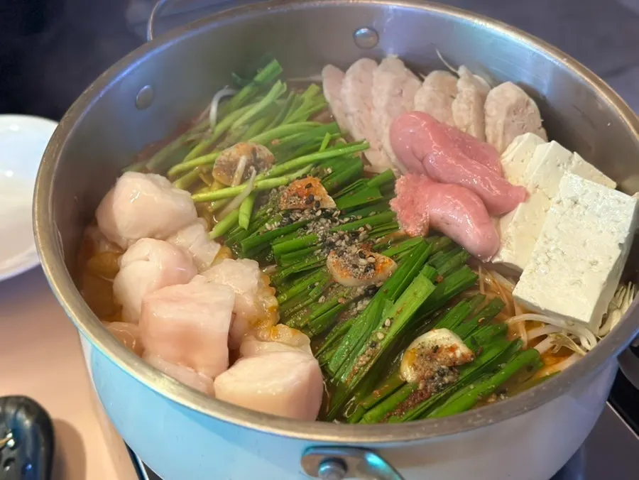Motsunabe pot topped with chives, pollack roe, and tofu