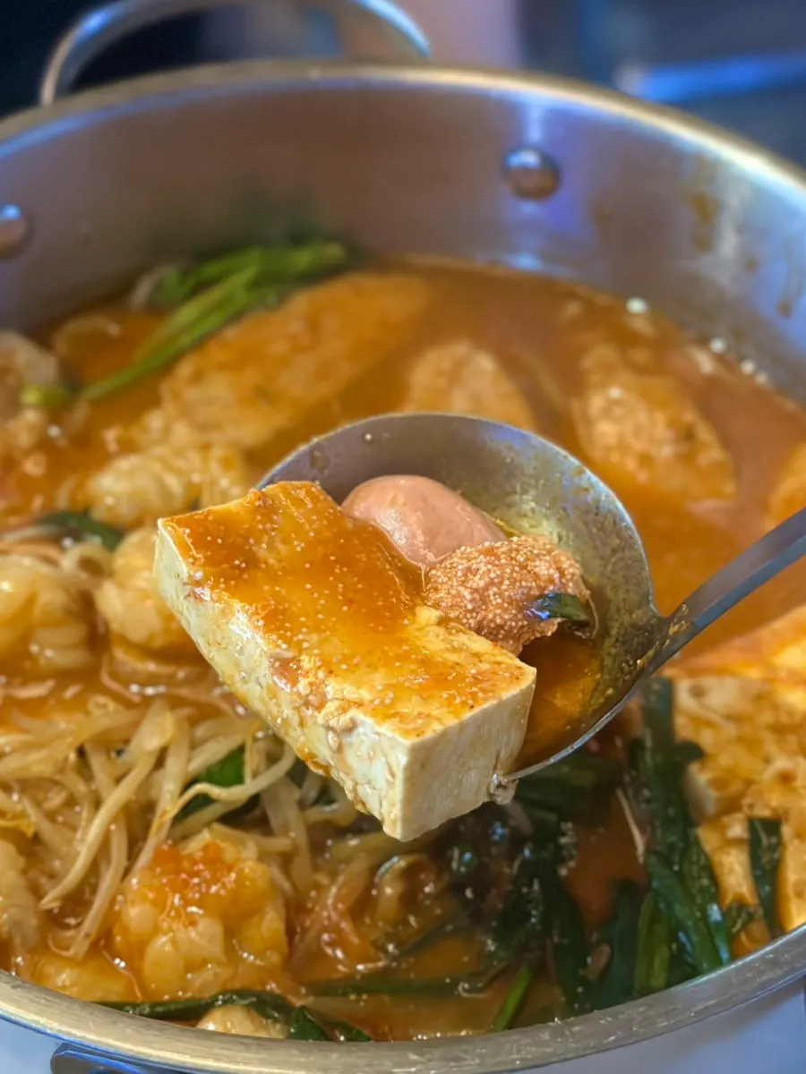Tsukune meatballs and tofu inside the motsunabe
