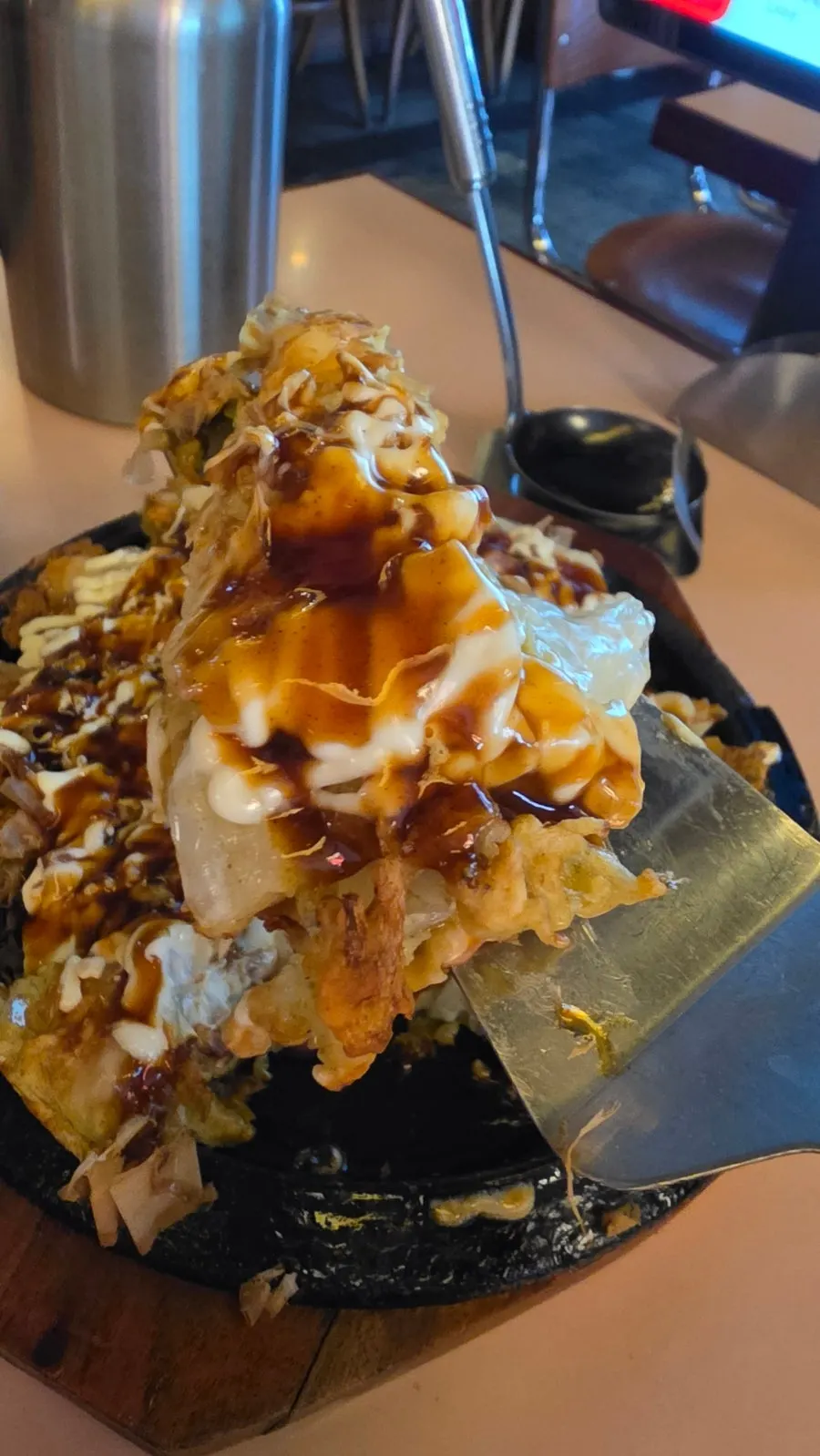 Okonomiyaki on a hotplate topped with bonito flakes