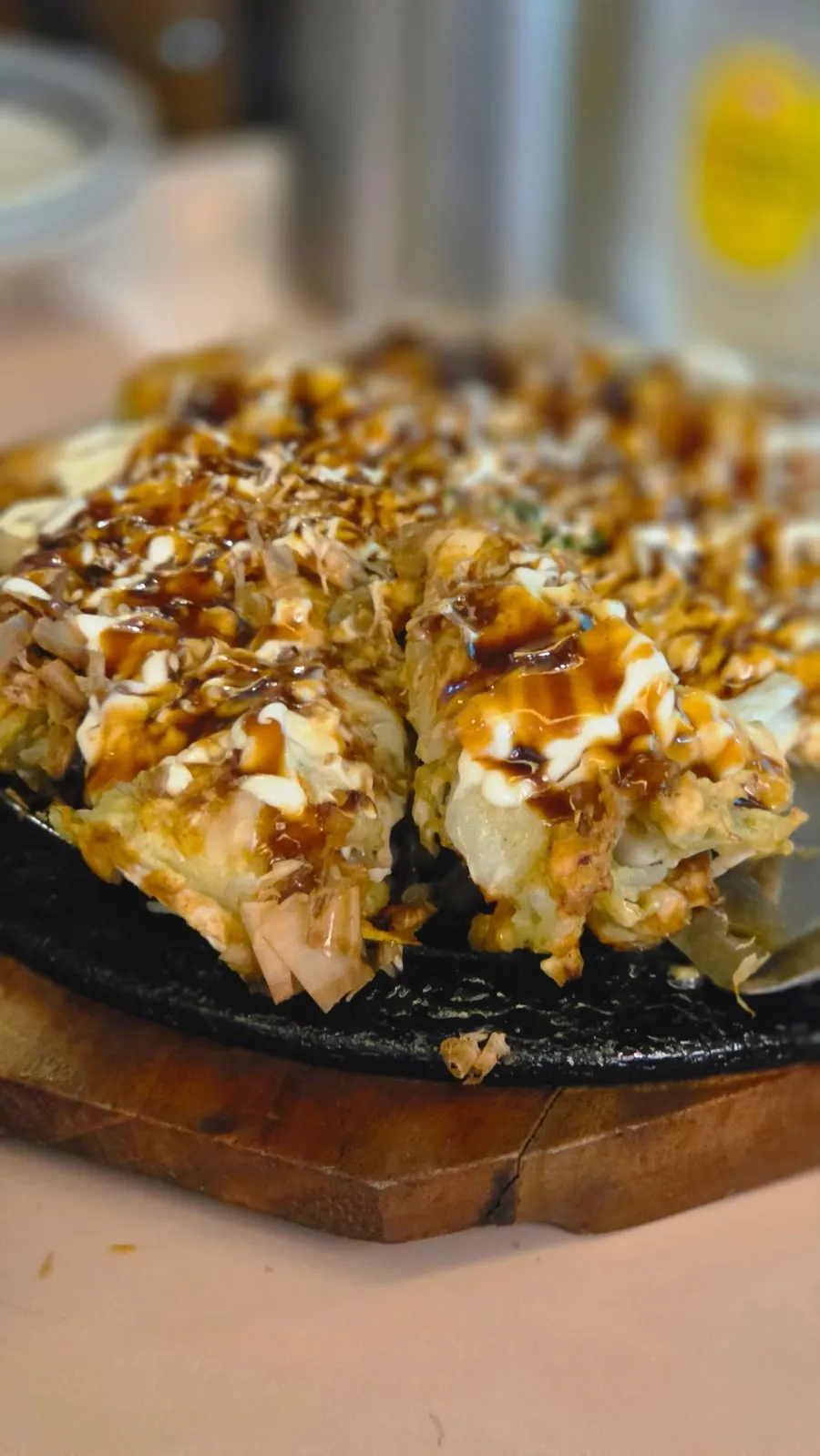 Okonomiyaki drizzled with sauce and mayonnaise