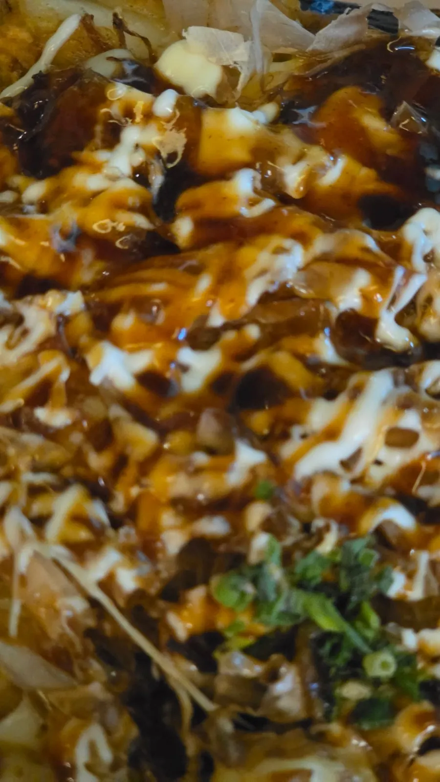Okonomiyaki sizzling on a hot plate