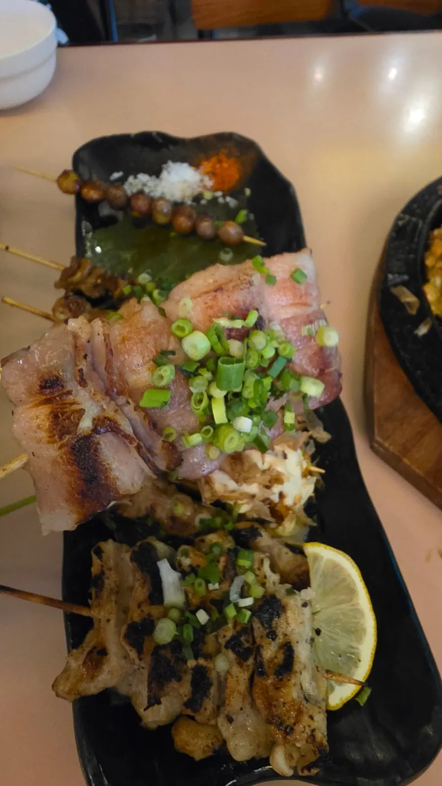 Grilled skewers topped with scallions and bonito flakes