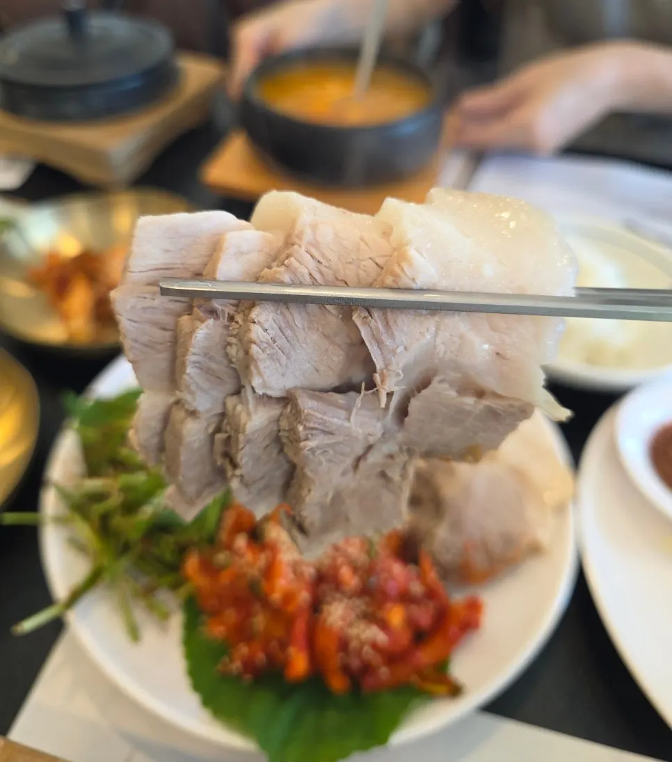 A bite of boiled pork topped with chive salad