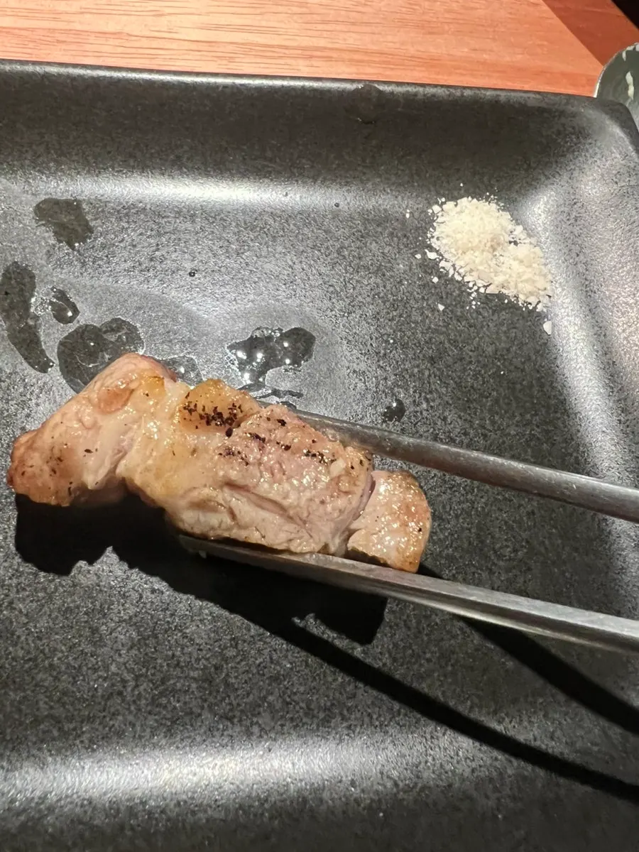 A well-grilled piece of samgyeopsal on the grill