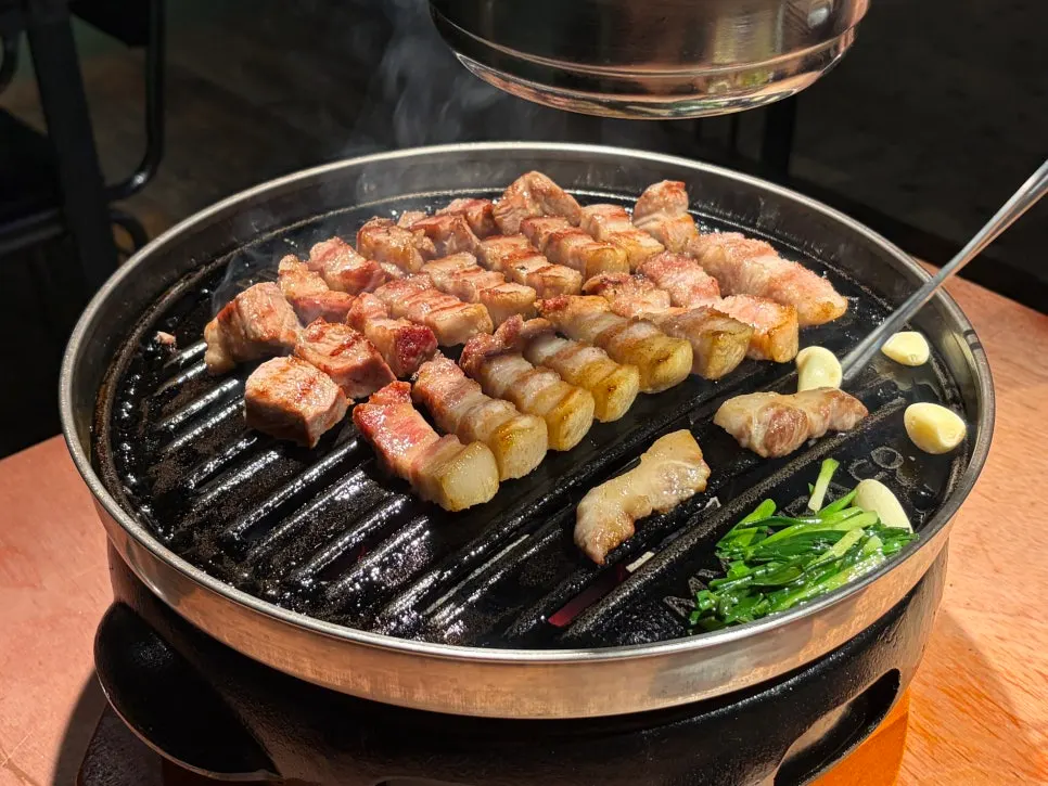 Staff member grilling Godansu's pork belly tableside