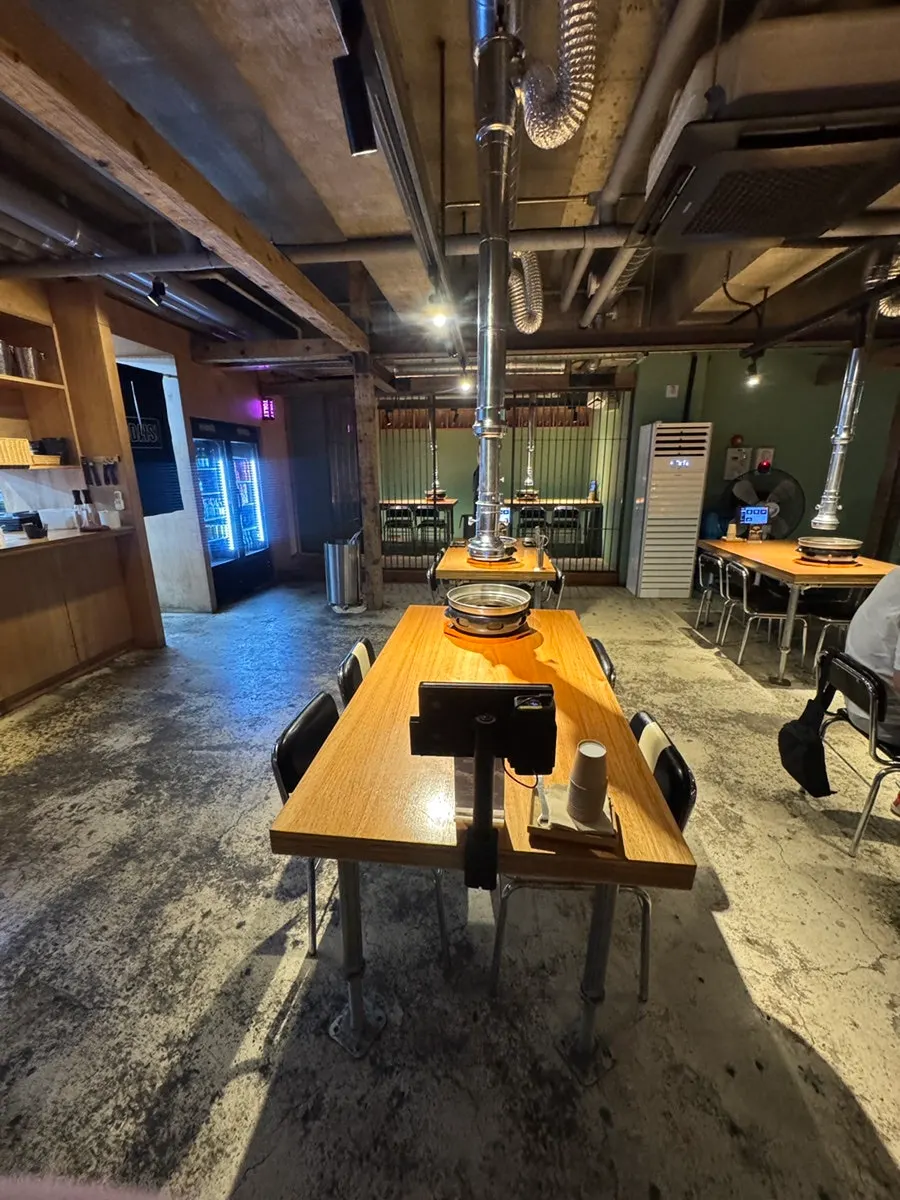 Interior with exposed concrete and wood tables