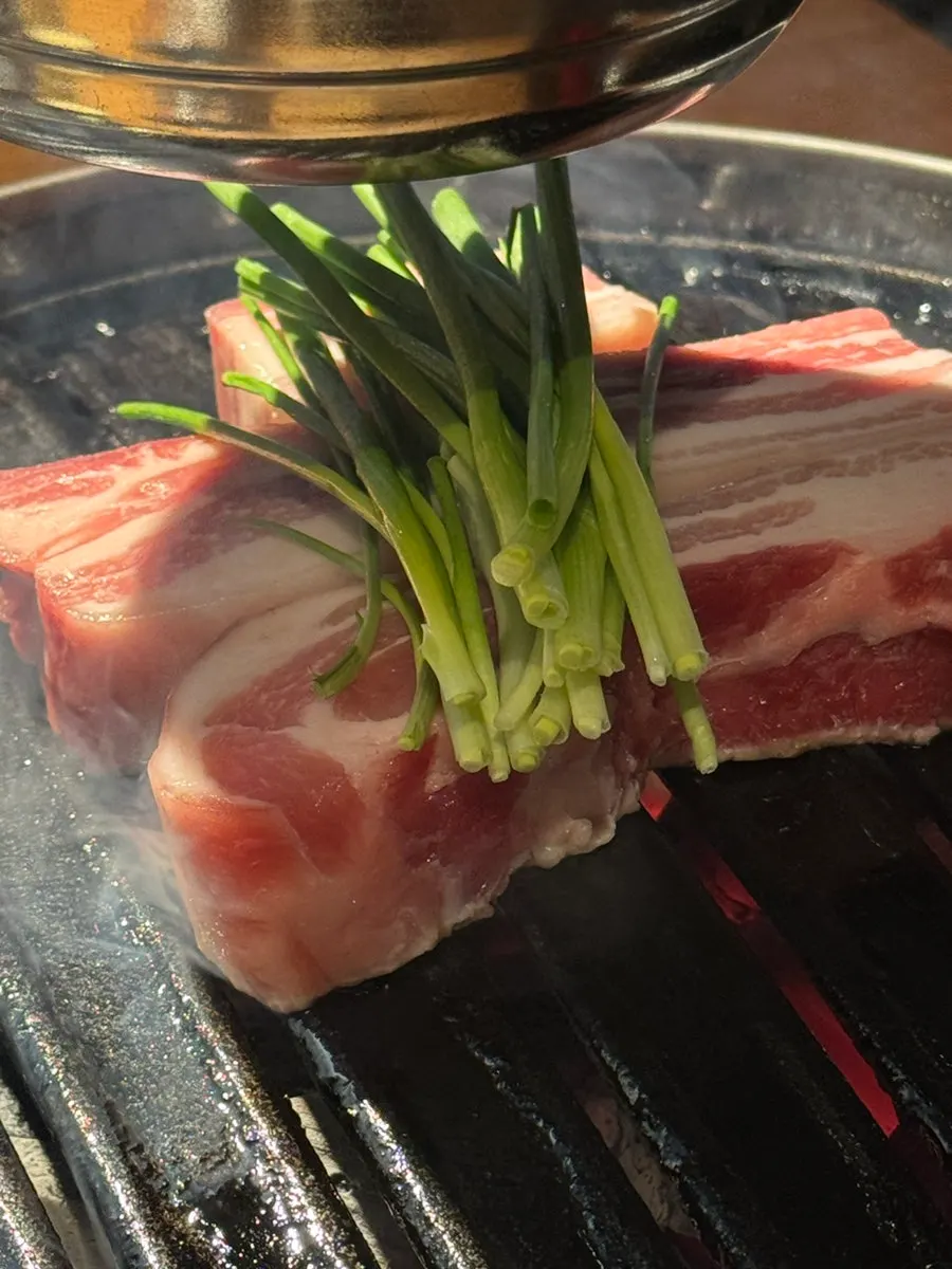 Three servings of aged pork belly served with green onion
