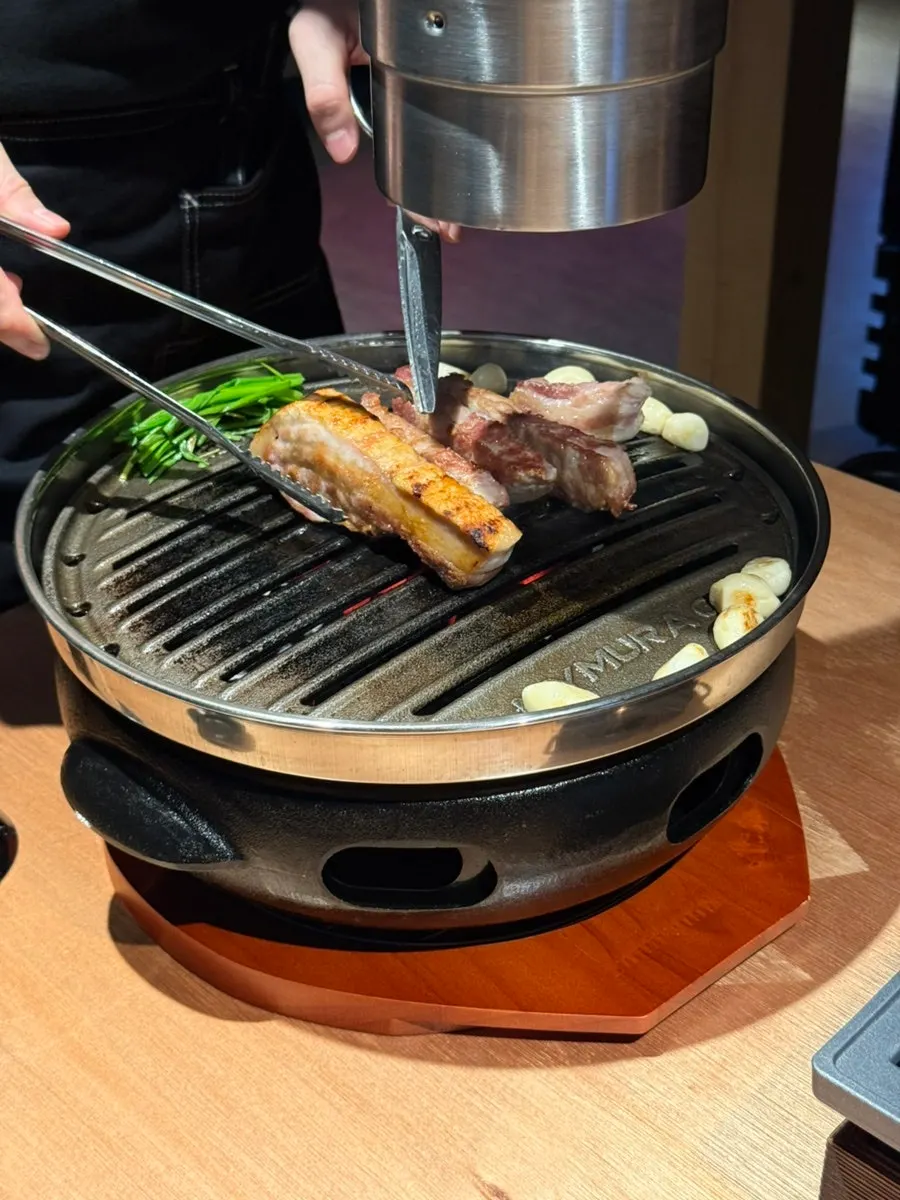 Staff member grilling the meat tableside