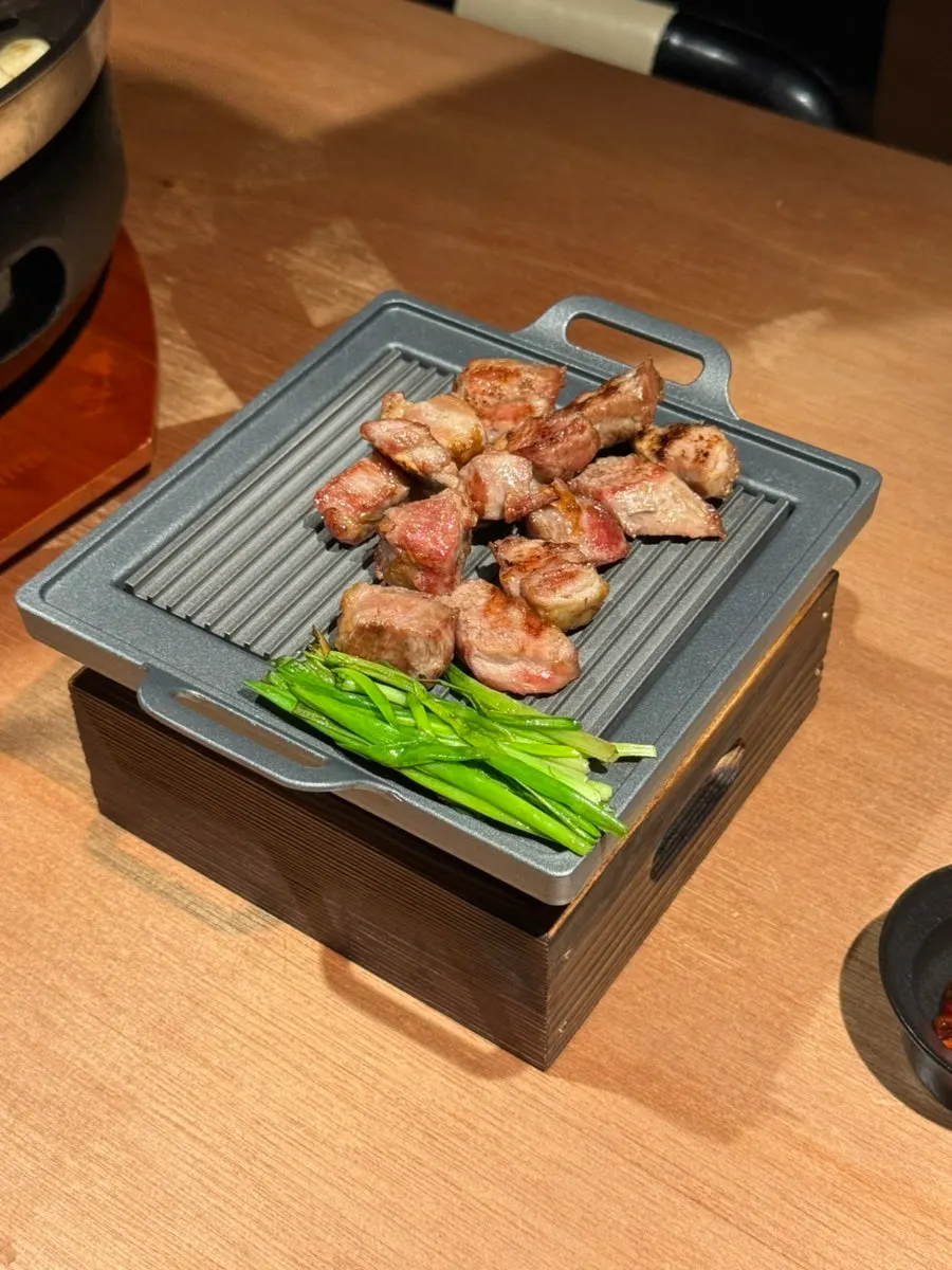A piece of pork belly plated onto the individual dish