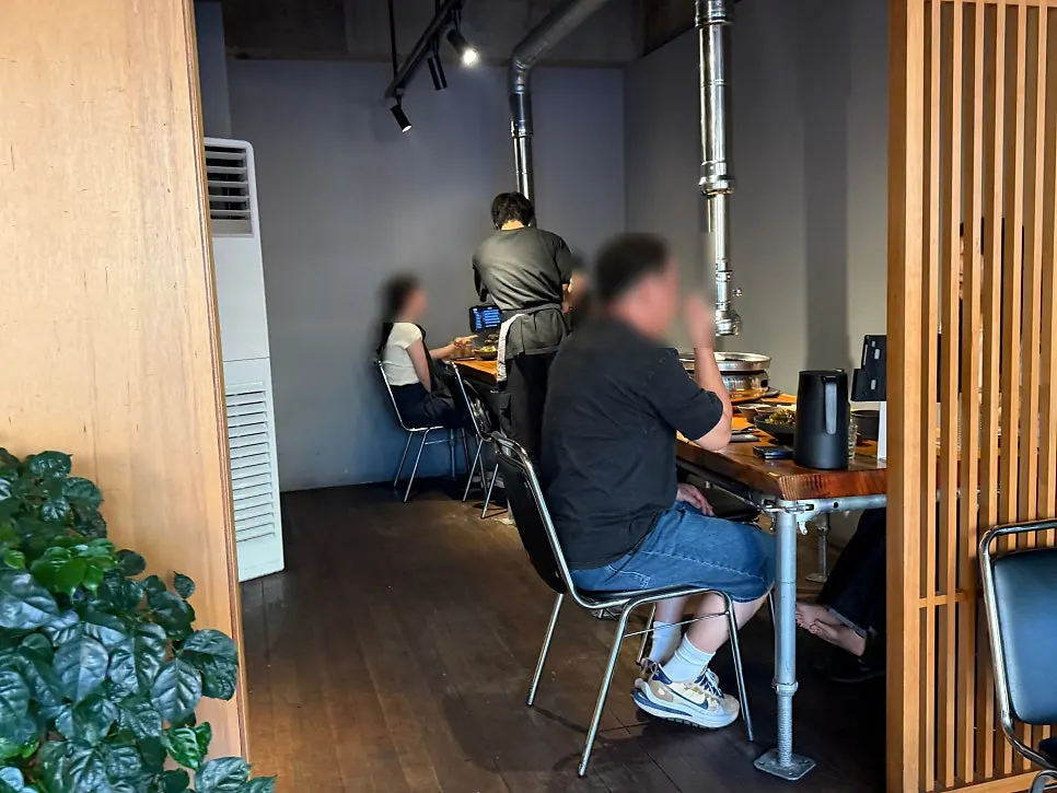 원목 테이블과 후드 배기가 늘어선 매장 내부
