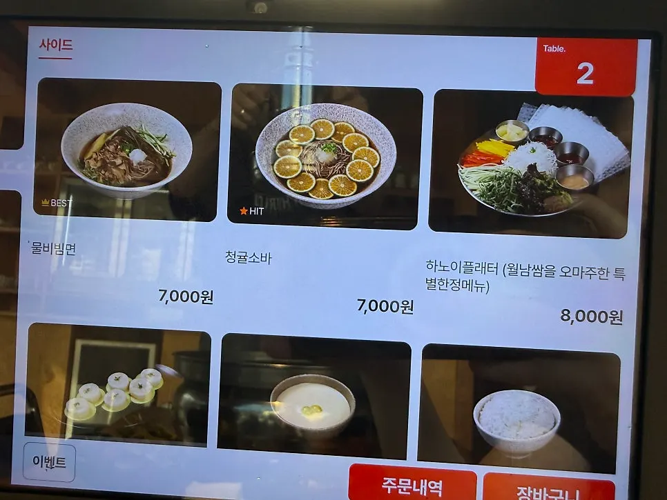 불판에서 익어가는 삼겹살과 밑반찬
