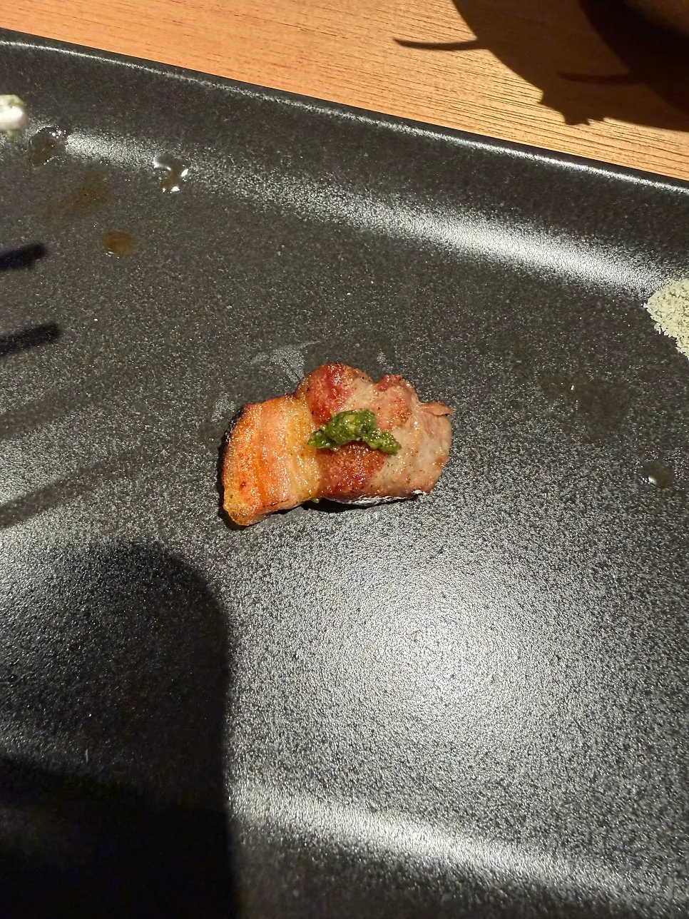 A piece of meat dipped in spinach basil pesto