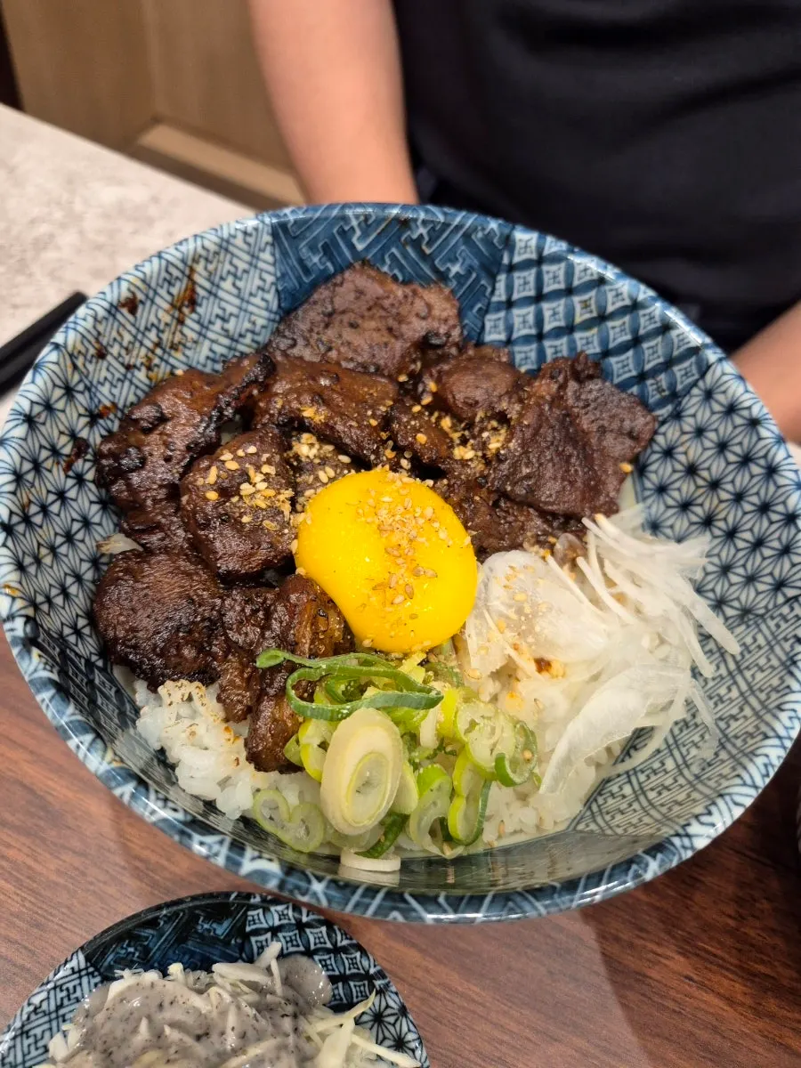 Spicy rib rice bowl topped with egg yolk
