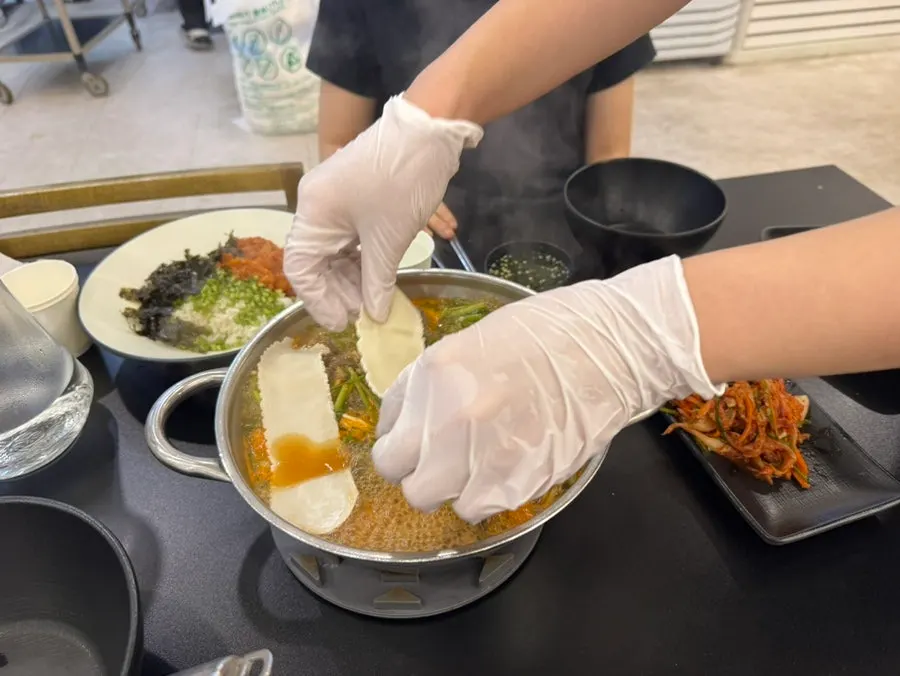 Sirloin and vegetables cooking in boiling red broth
