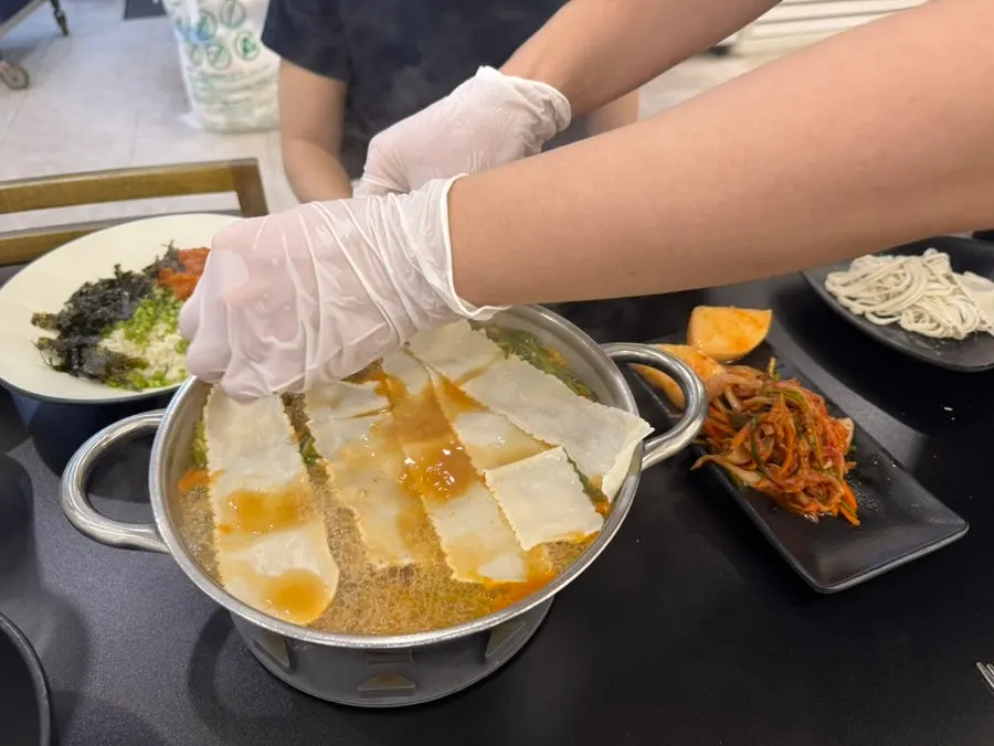 Pot of hearty shabu broth full of vegetables and meat