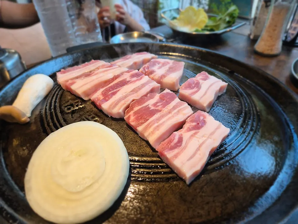 솥뚜껑 불판 위에서 구워지는 삼겹살