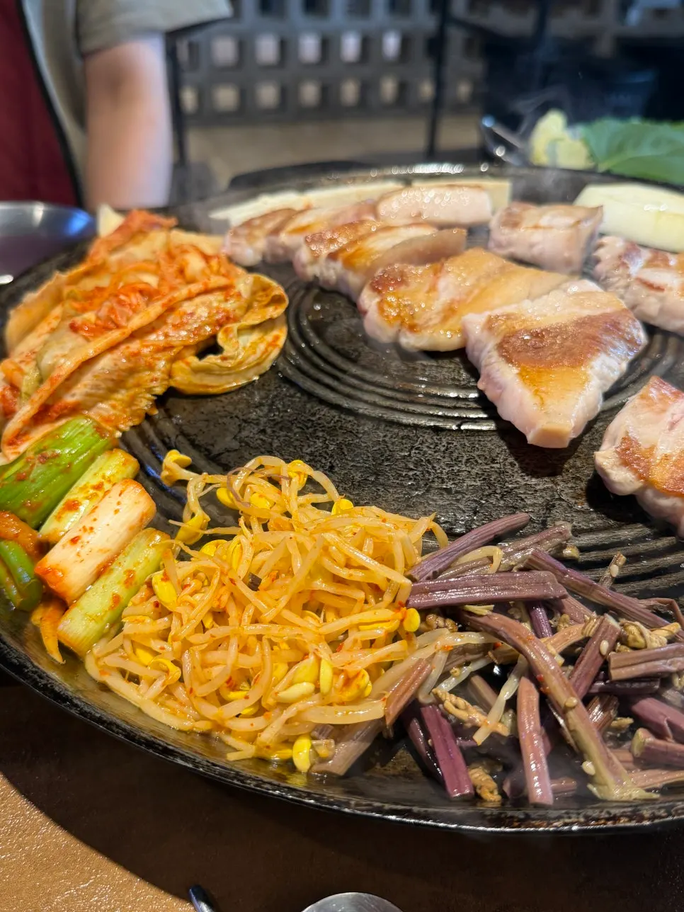 솥뚜껑 위에서 익어가는 오겹살과 김치