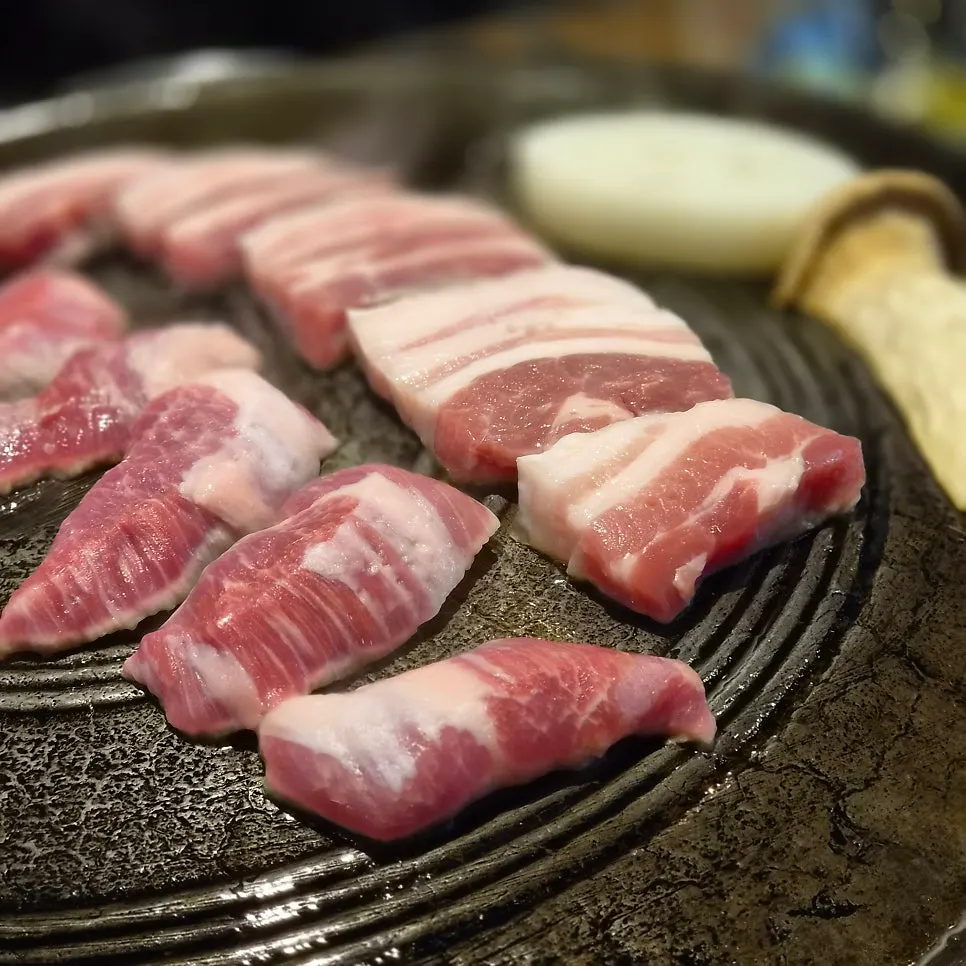솥뚜껑에 올려 굽기 시작한 두툼한 생오겹살