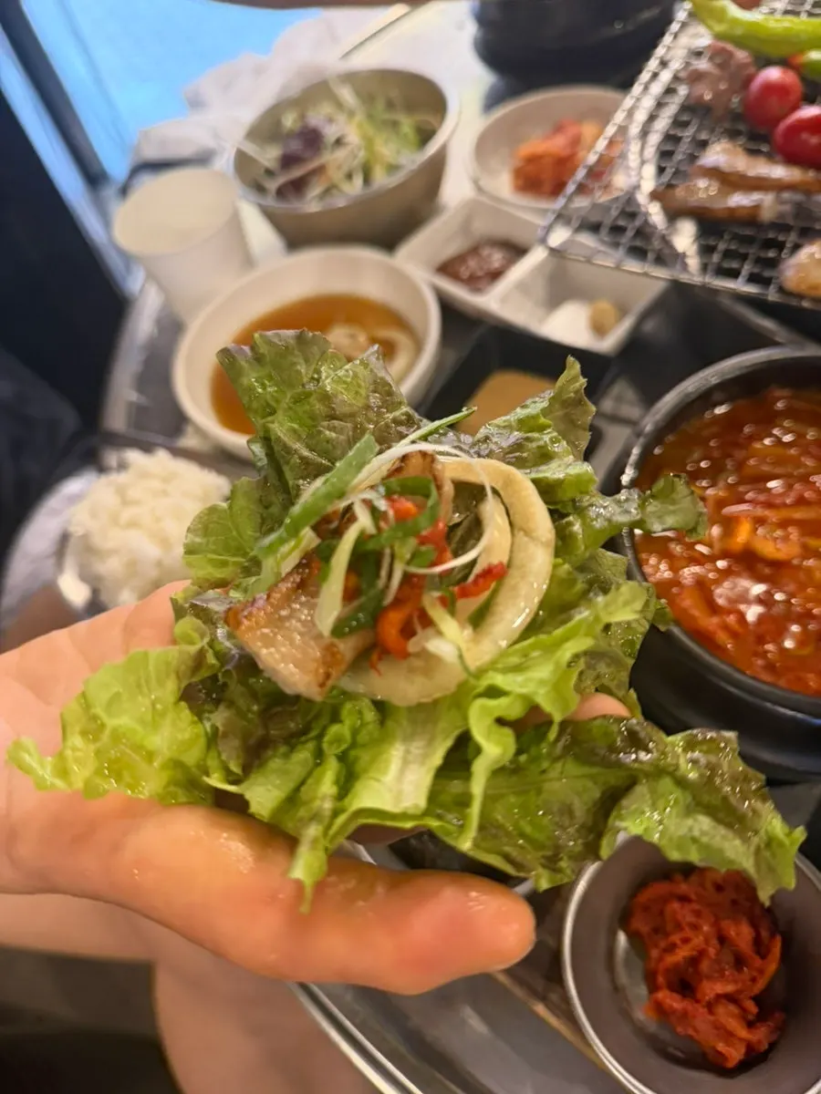 상추에 고기와 채소를 싸는 모습