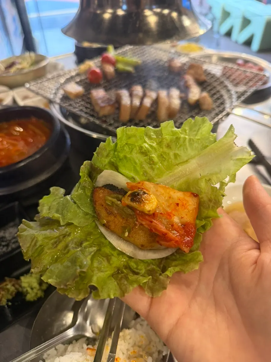 구운 고기와 쌈 채소가 놓인 테이블