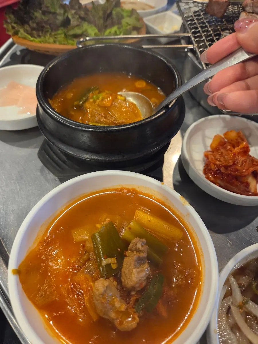 Table spread with kimchi jjigae and meat