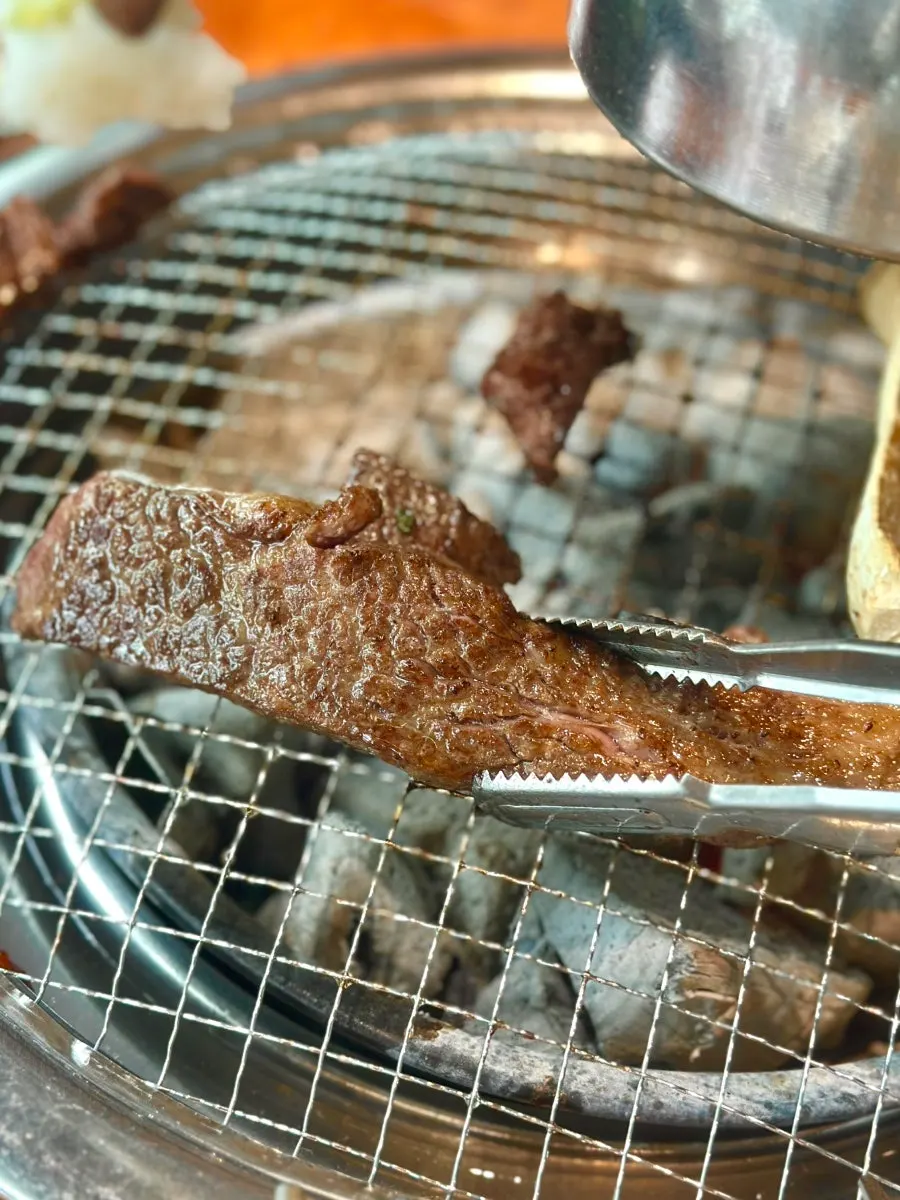 Beef grilling over charcoal