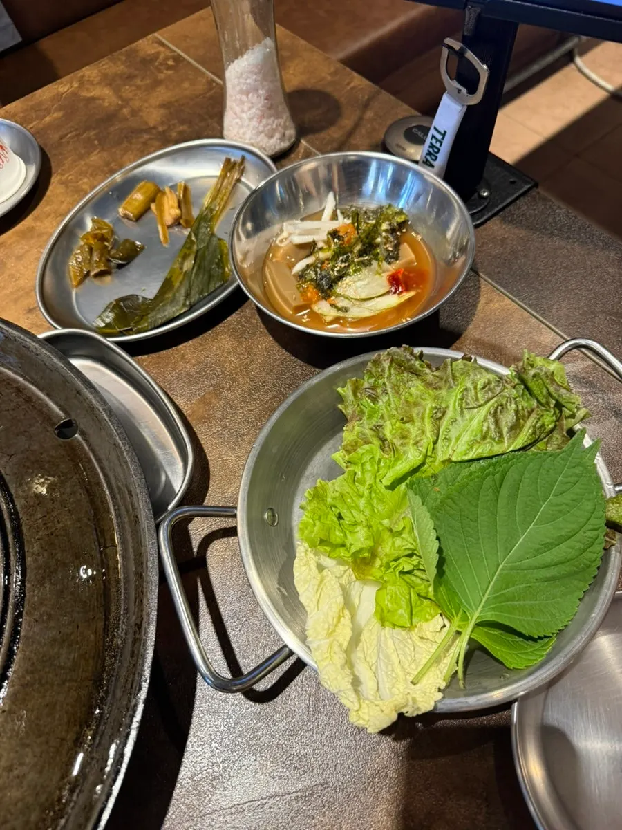 A spread of side dishes including lettuce wraps and pickles