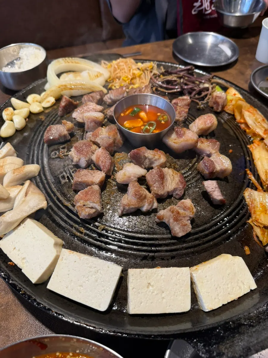 A fully loaded cauldron lid of cooked pork neck and vegetables