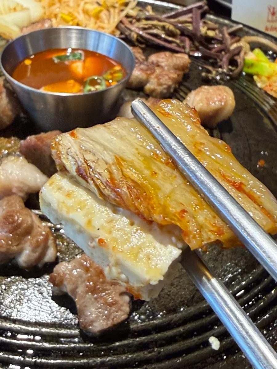 A bite of grilled kimchi and tofu with meat