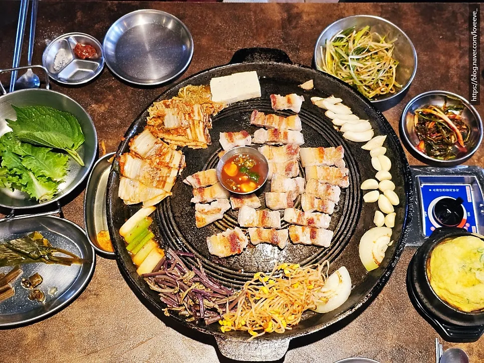 Fully grilled pork belly on the cauldron lid