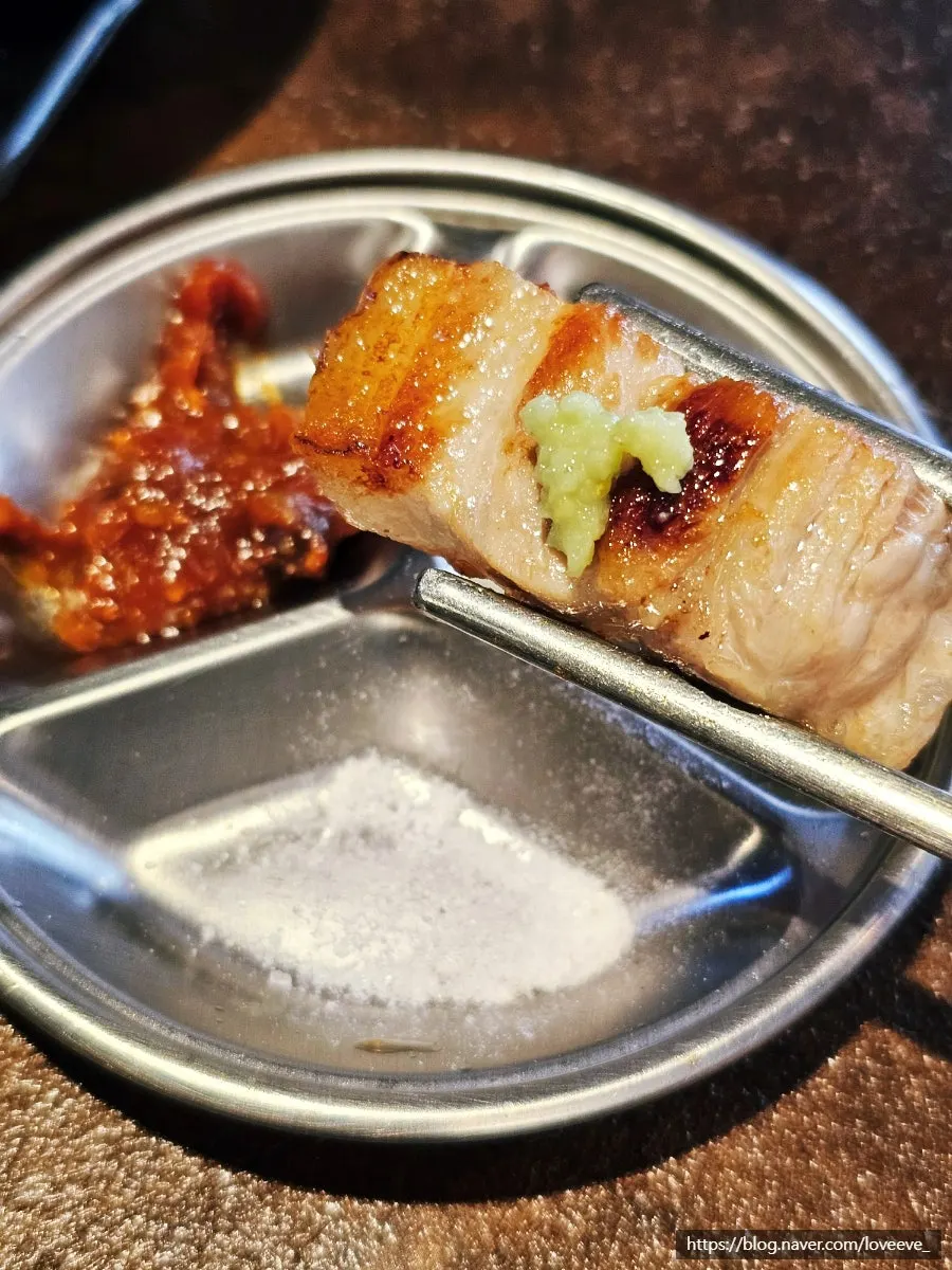 A piece of pork belly picked up with chopsticks