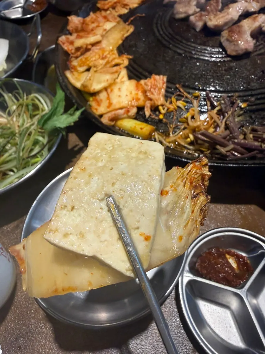 Kimchi and tofu cooking on the cauldron lid