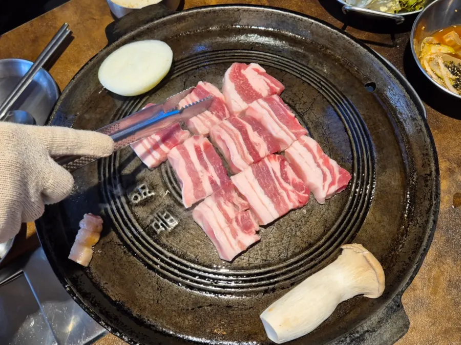 Two thick, vivid pink-red servings of raw pork belly