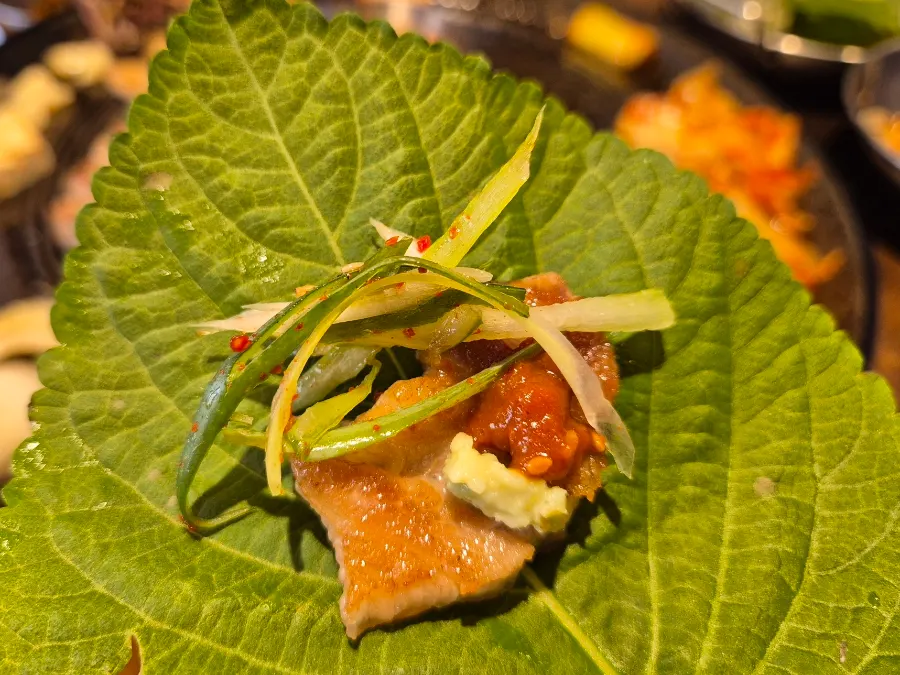 A large lettuce wrap filled with pork belly