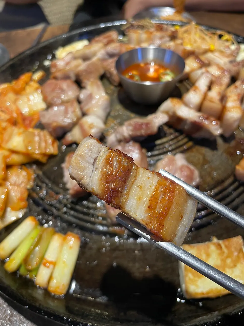 솥뚜껑에 고기와 김치 두부를 함께 올린 모습