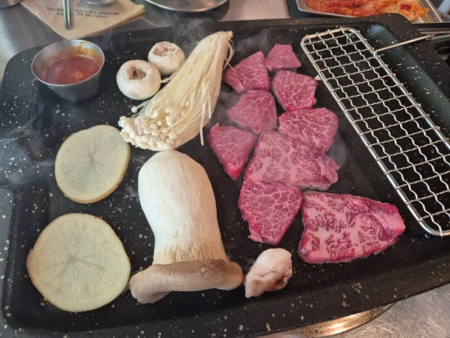 고기와 함께 차려진 반찬과 채소