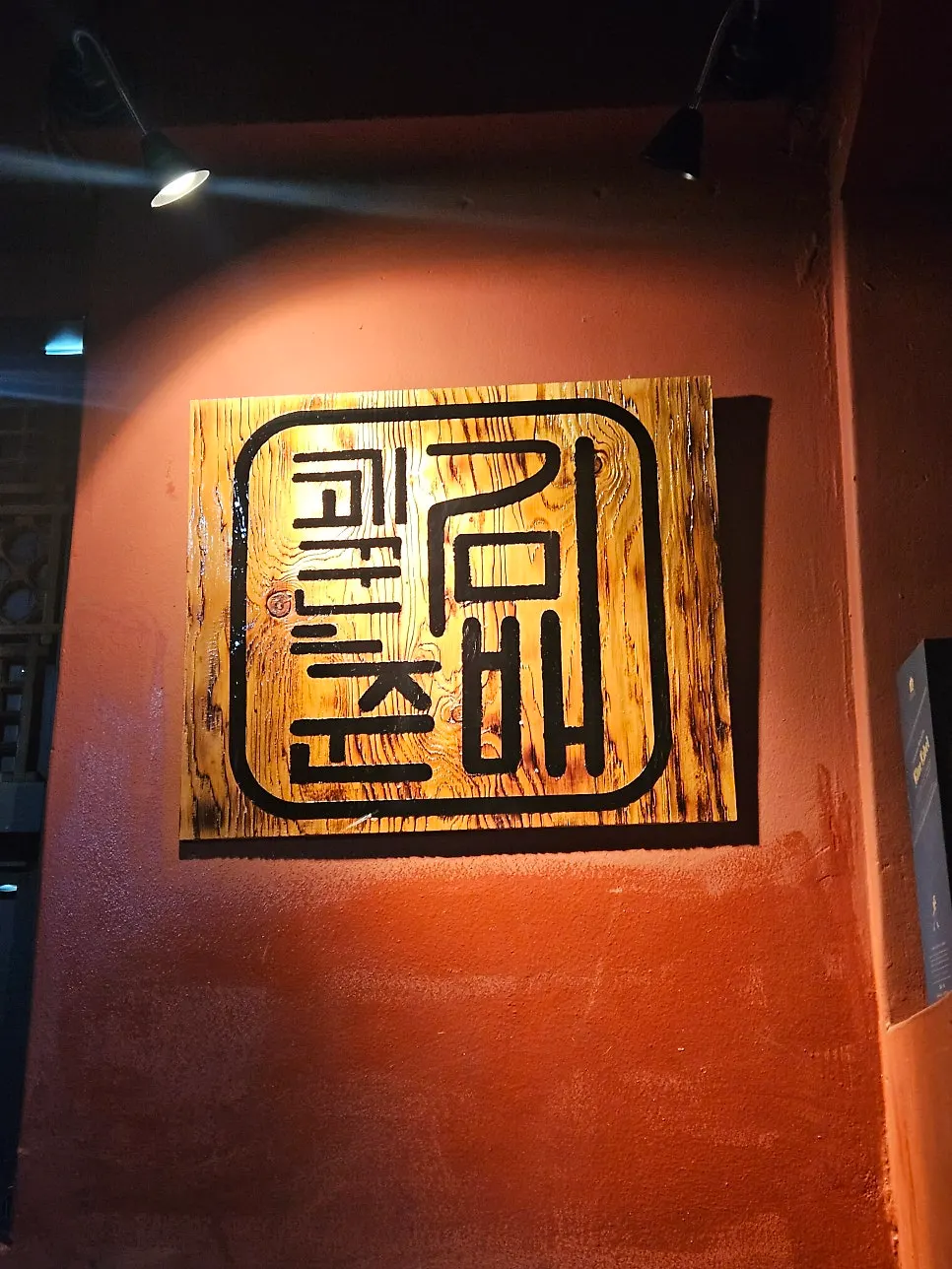 Restaurant entrance with a wooden sign and red wall