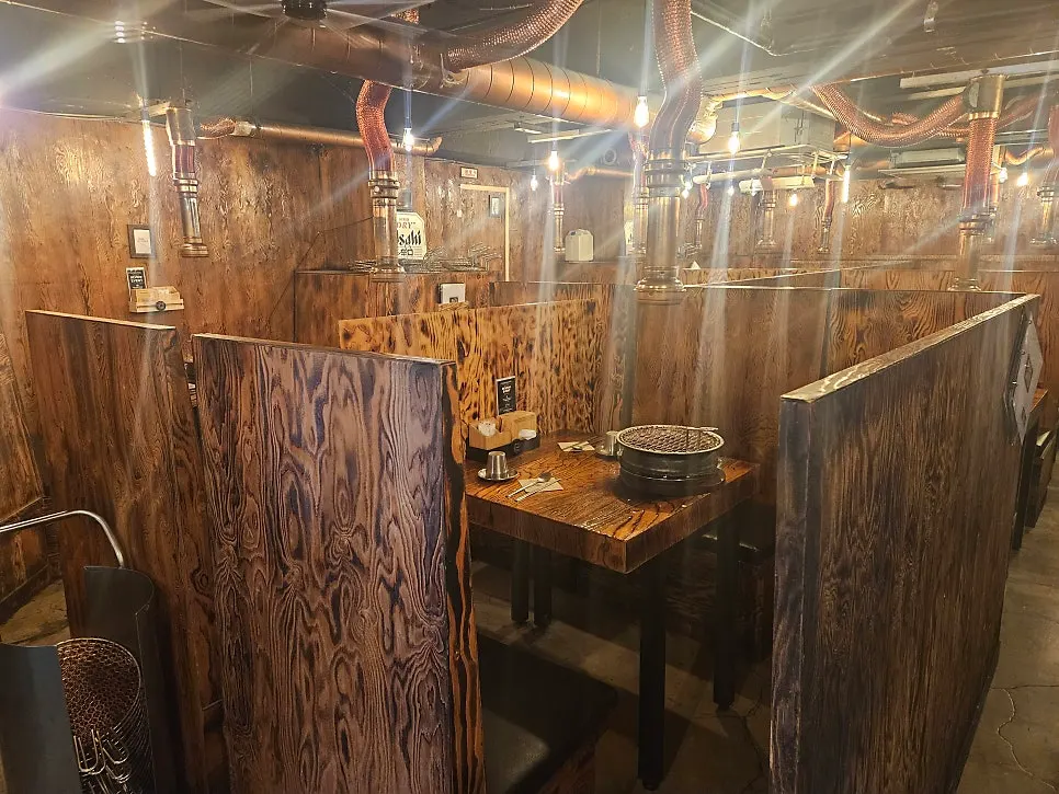 Restaurant interior with wooden tables and partitions running throughout