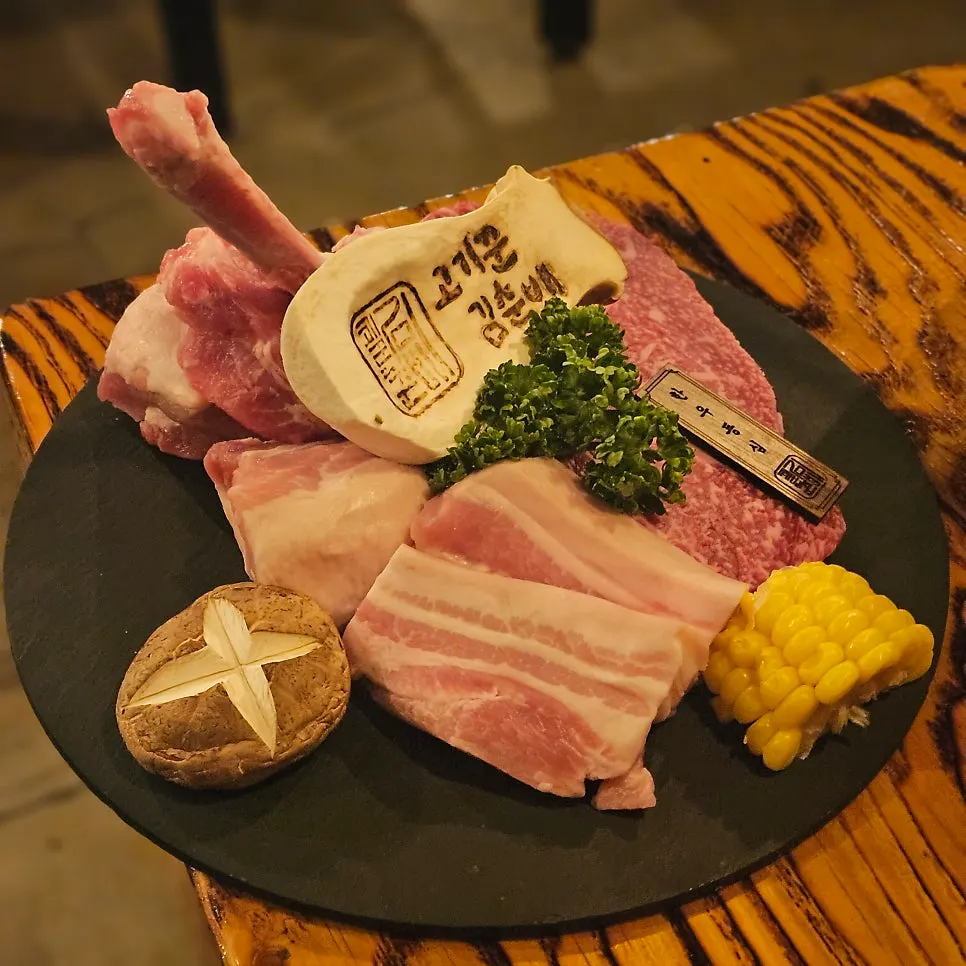 Pork belly and beef plated with shiitake mushrooms and corn
