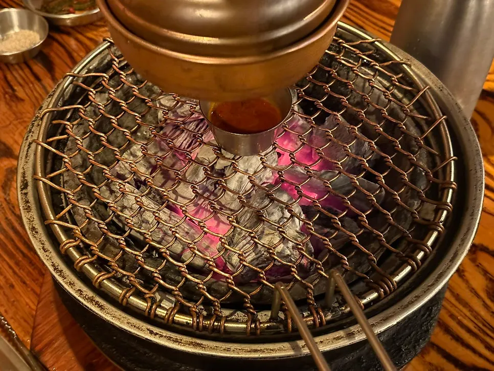 The charcoal grill set up with myeoljeot sauce