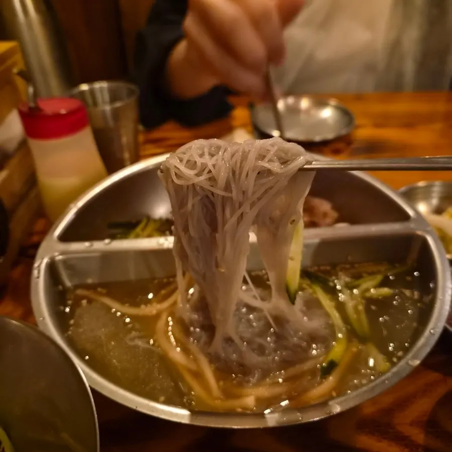 Half-and-half naengmyeon with mul-naengmyeon and bibim-naengmyeon side by side