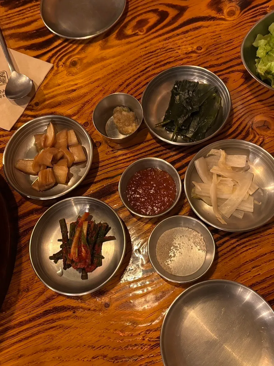 Side dish spread including wild garlic namul and pickled onions