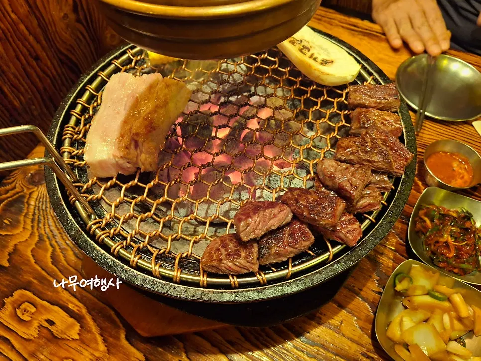 Staff member grilling meat over the charcoal fire