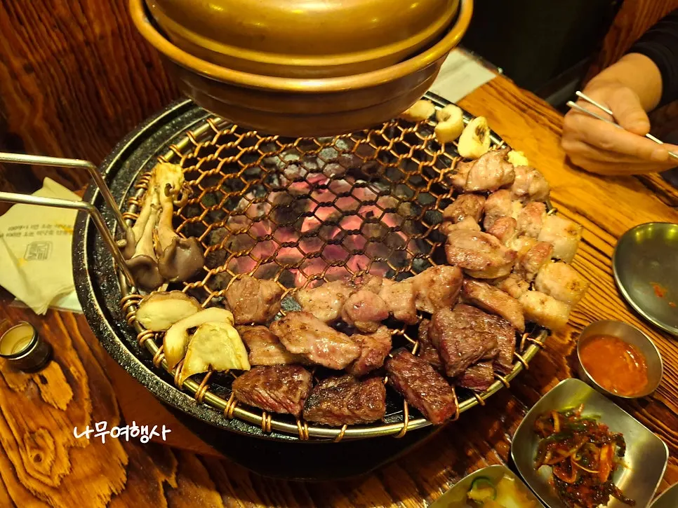 Grill grate with hanwoo sirloin, pork neck, and pork belly all finished