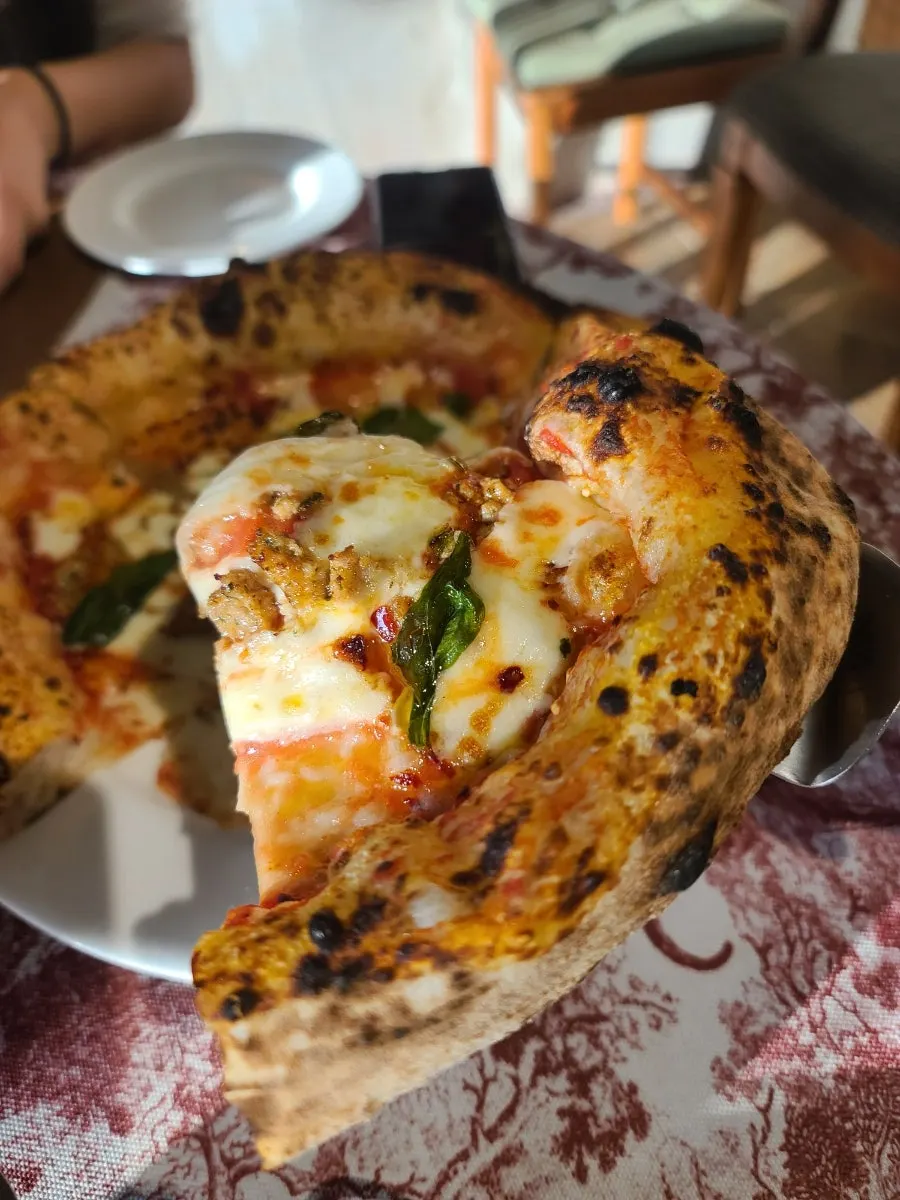 Golden-baked crust edge of the Salsiccia pizza