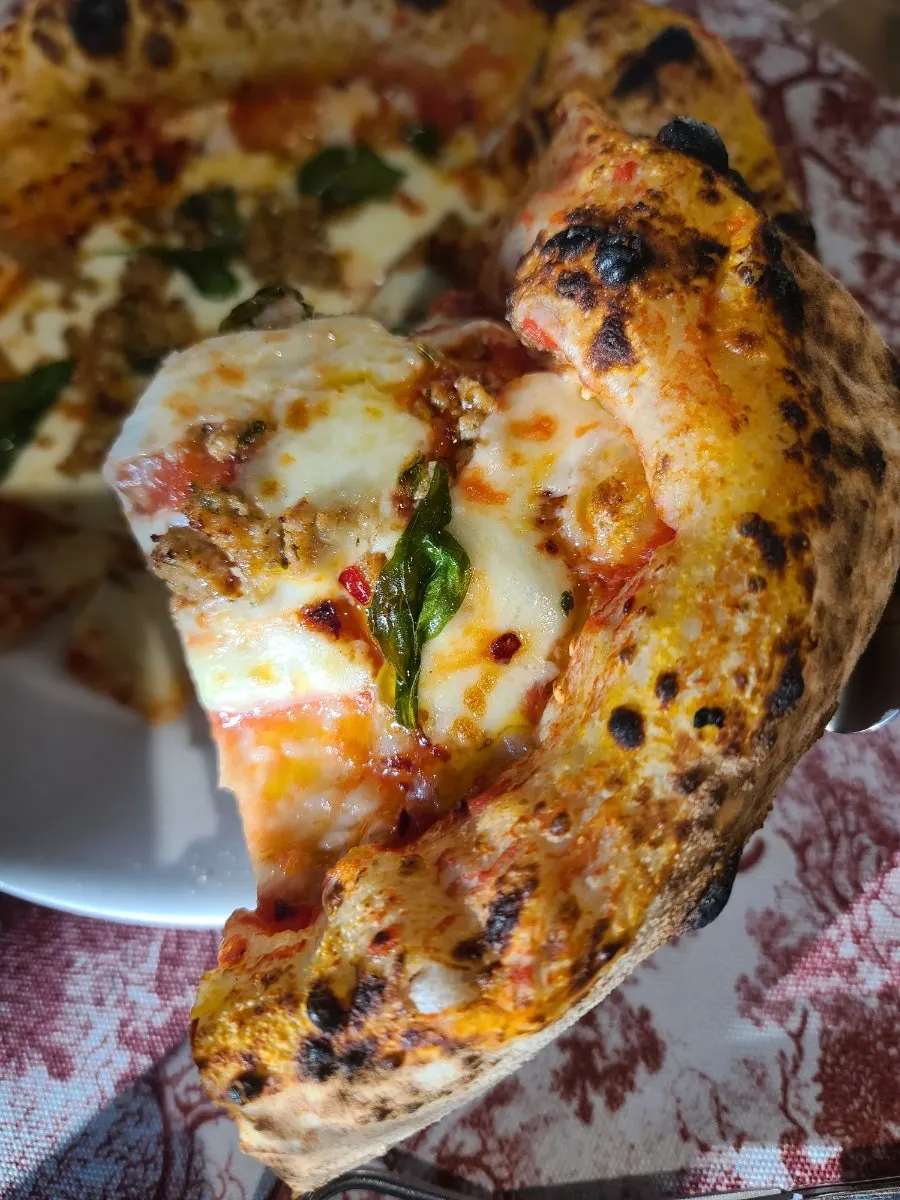 A hand-cut slice of Salsiccia pizza