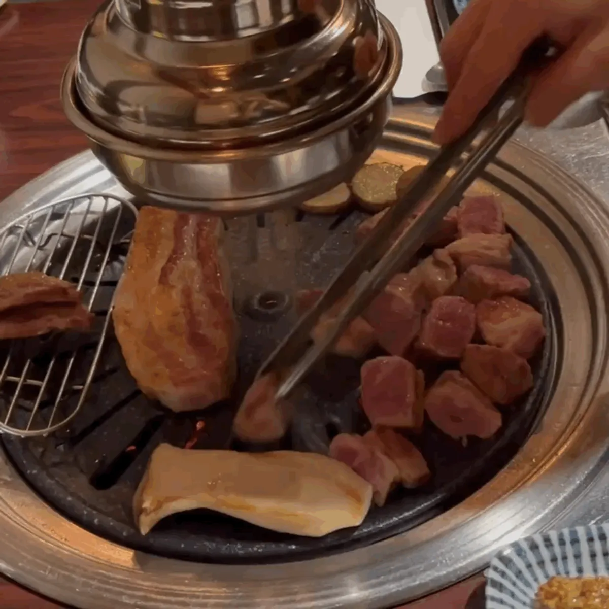 Pork neck and pork belly grilling on the pan at Gogi Salon
