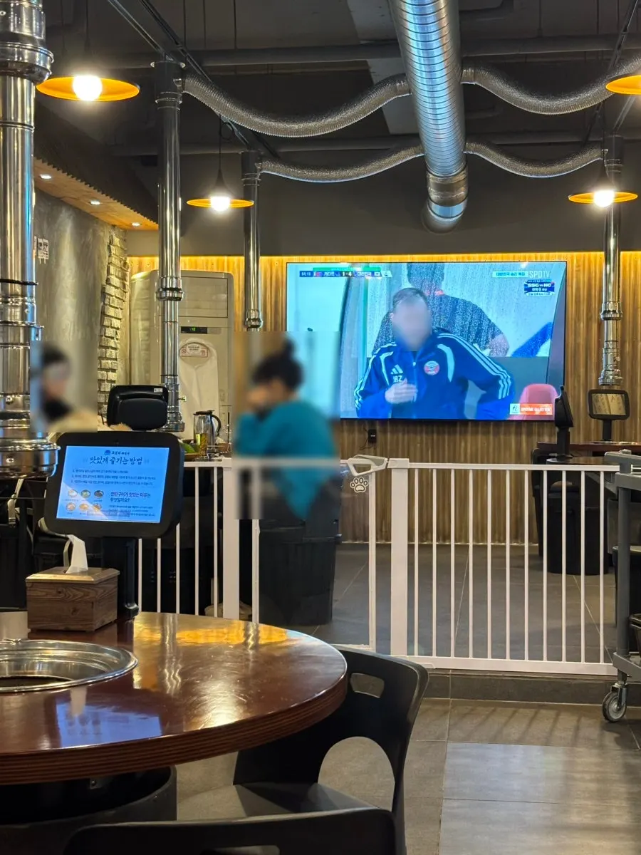 Wall with a large TV and table seating