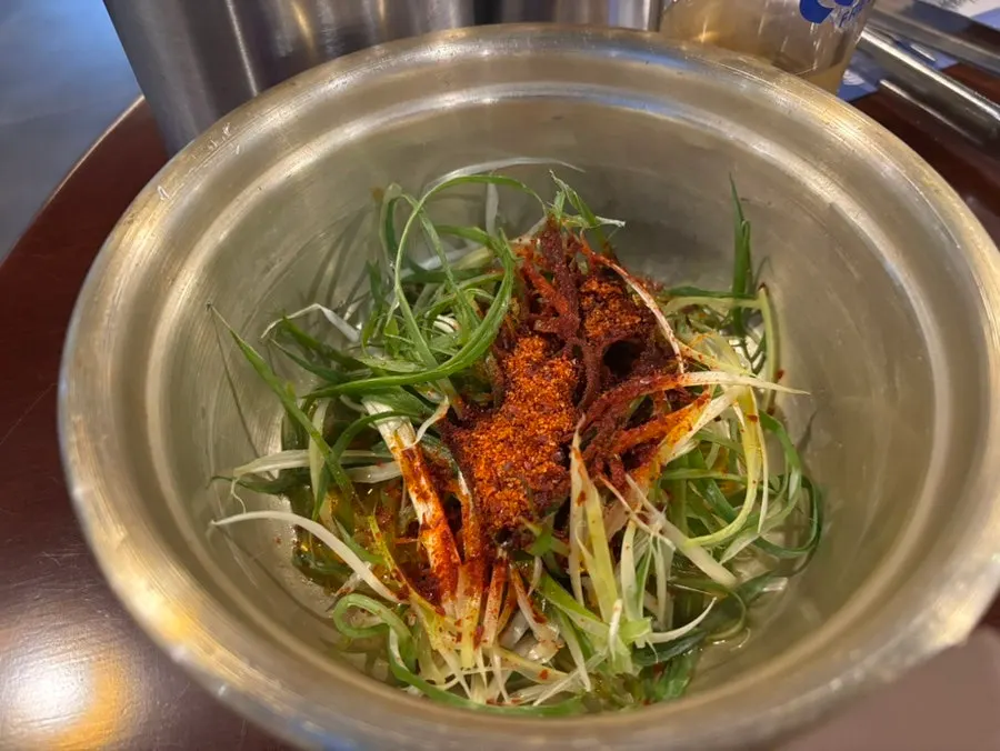 Shredded scallion side dish served with the meat