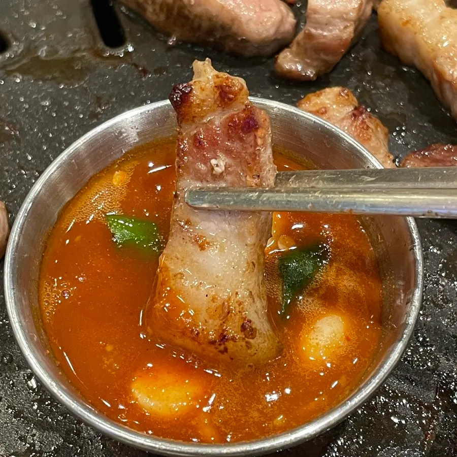 구운 김치를 올린 김치삼겹살 한 점
